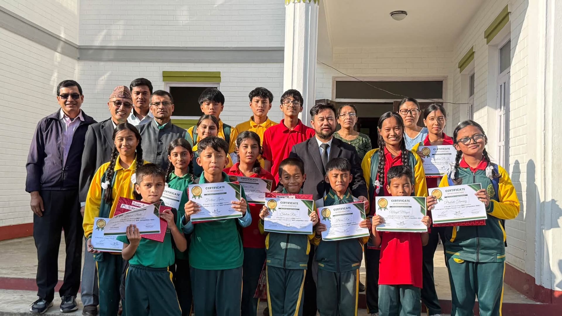 Students holding certificates with teachers on achievement day