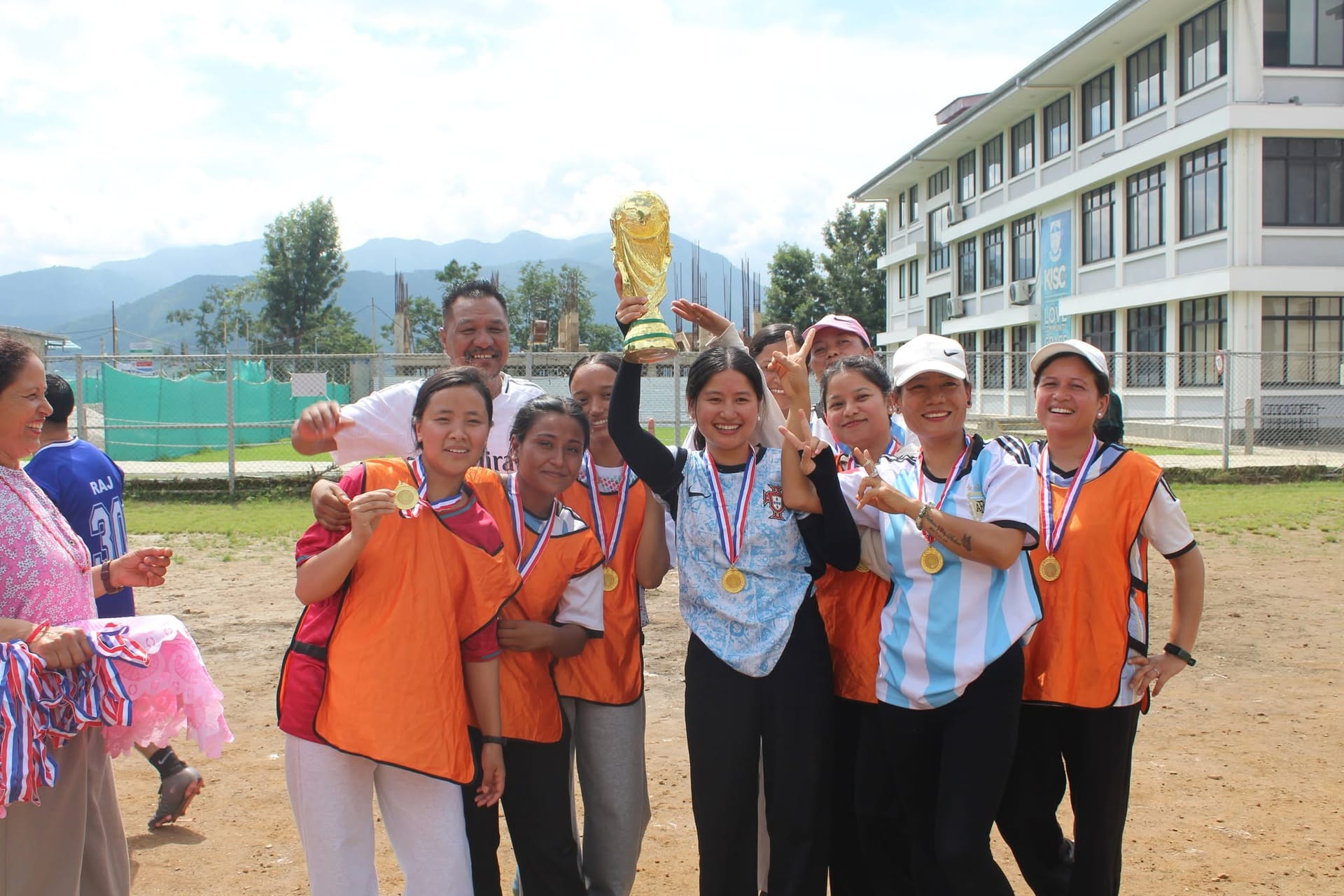 Somang students celebrating a sports victory with a trophy